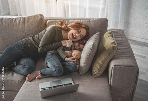 Fotografi Full length portrait of smiling mother and daughter fooling around at home