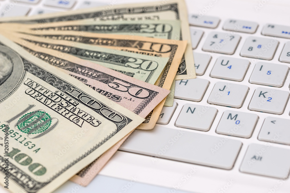 dollar bilsl on white keyboard laptop. close up dollar bilsl on white keyboard laptop. close up