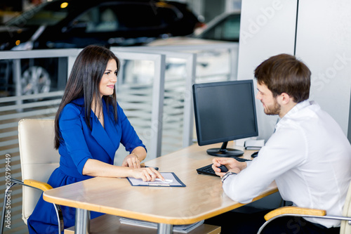 Customer woman asking dealer about definite terms in loan agreement in meeting room