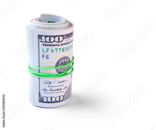 100 dollar bills twisted into tube and tied with an elastic band. Isolated on white background.