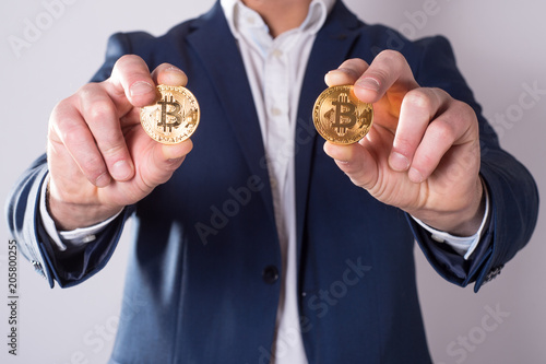 Golden Bitcoin in a man hand, Digitall symbol of a new virtual currency