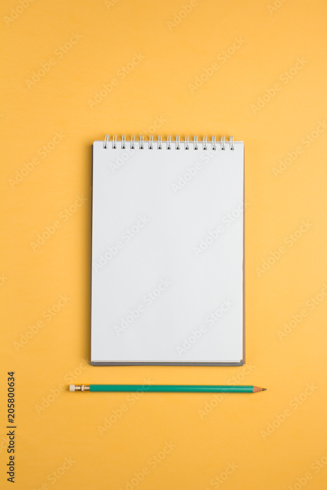 Blank notebook with on yellow pastel background. Flat lay concept. Vertical orientation Blank notebook with on yellow pastel background. Flat lay concept. Vertical orientation