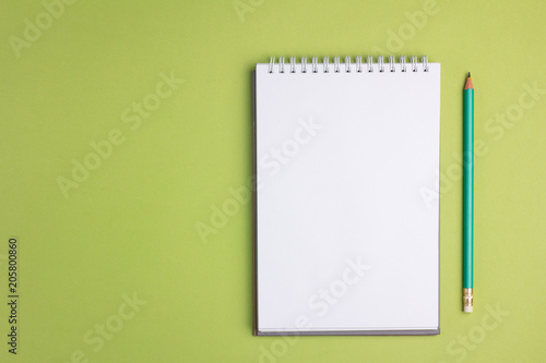 Blank notebook on green pastel background. Flat lay concept. Copy space