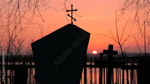 A monument in the cemetery on the sunset background photo