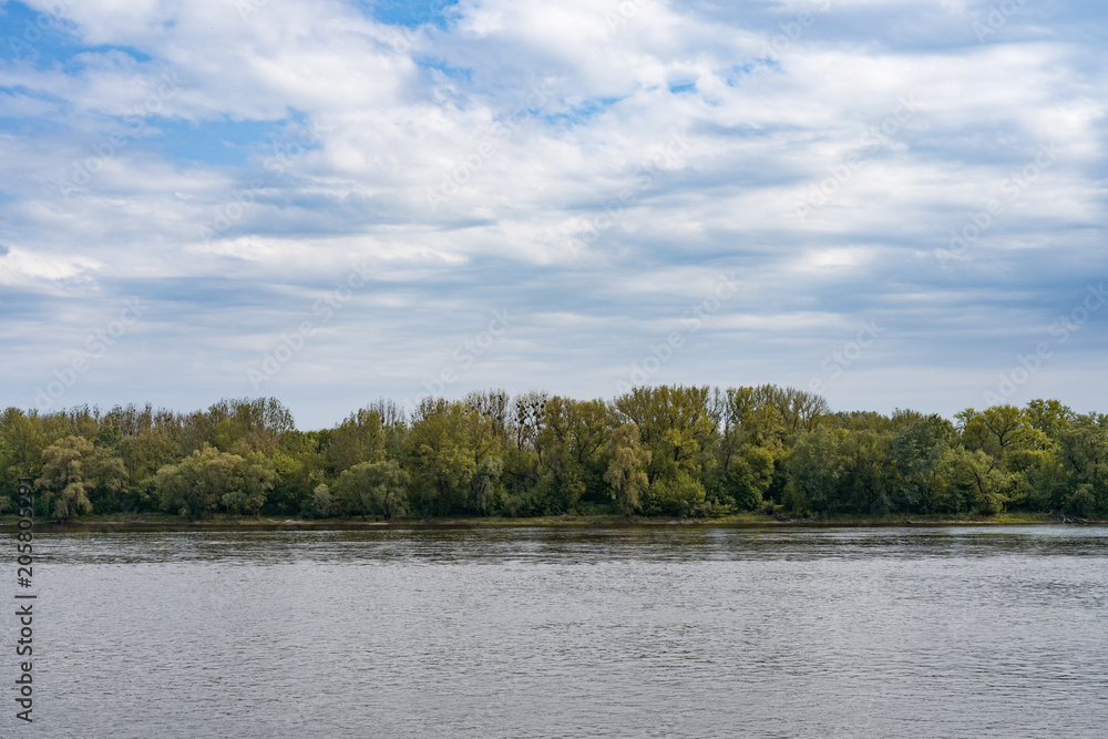 Idyllic view of river, forest and blue sky with clouds. Idyllic view of river, forest and blue sky with clouds.