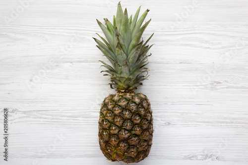 Ripe pineapple on a white wooden background. From above. Top view.
