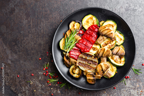 Grilled vegetable salad. Salad of barbecued zucchini, eggplant, sweet pepper, onion and mushrooms on black plate