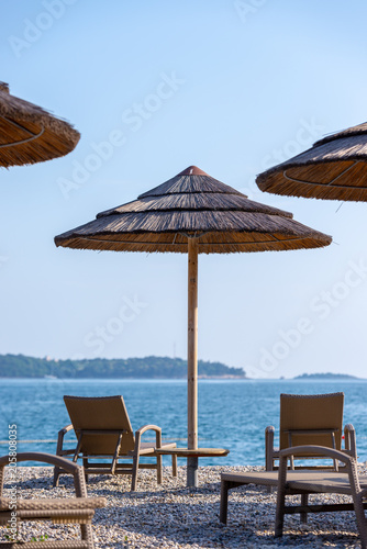 Reed umbrellas and deck chairs on the beach