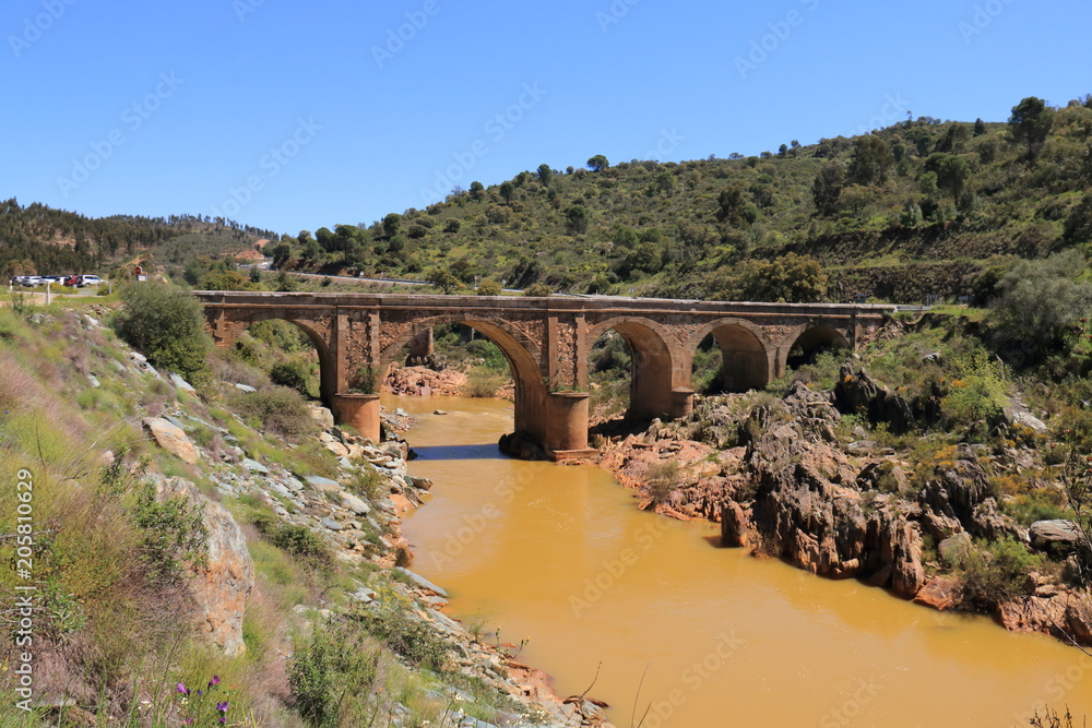 Old stone bridge over the Odiel river, on the route of the mills, great for hiking in the province of Huelva, Spain