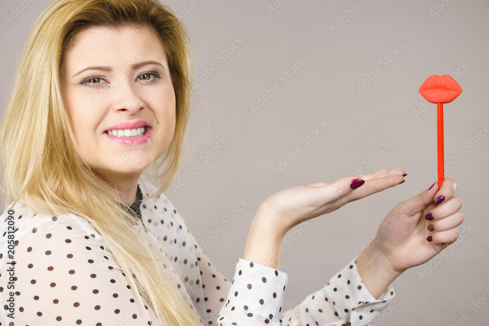 Happy woman holding fake lips on stick Happy woman holding fake lips on stick