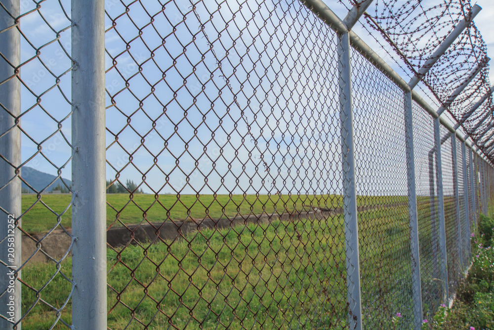 Chain link fence with grass field Phuket International Airport Chain link fence with grass field Phuket International Airport