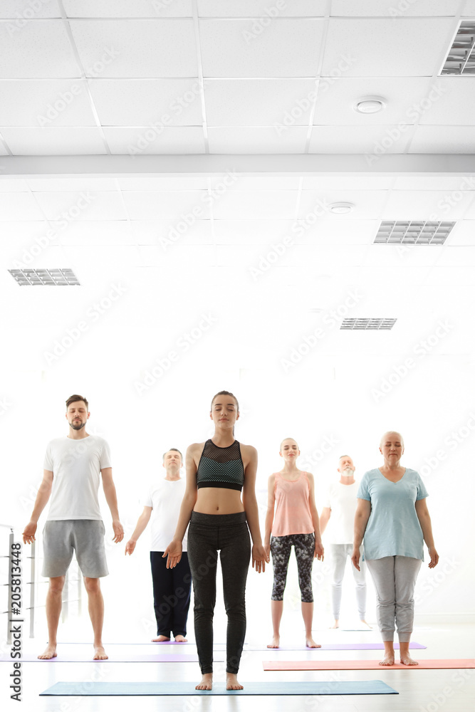 Fototapeta premium Group of people in sportswear practicing yoga indoors