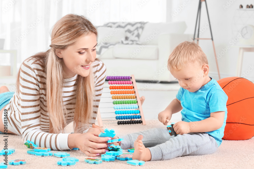 Baby and mother playing with puzzle at home