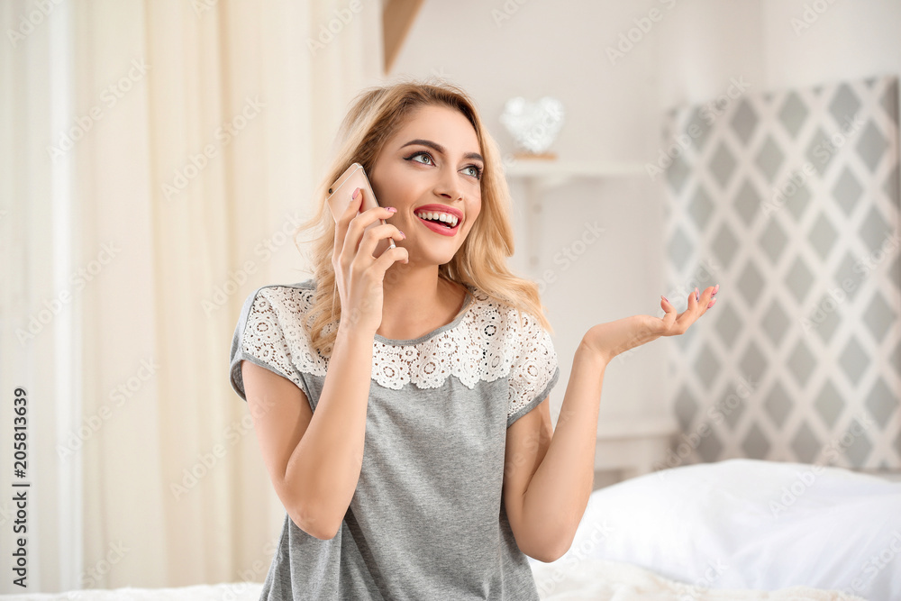 Young beautiful smiling woman talking on phone at home Young beautiful smiling woman talking on phone at home