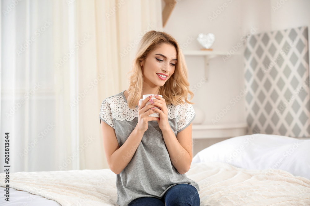 Young beautiful smiling woman with cup of coffee at home Young beautiful smiling woman with cup of coffee at home
