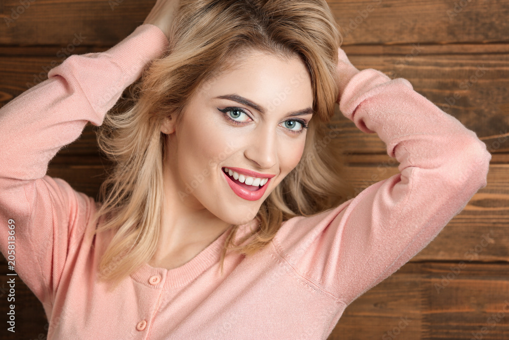 Young beautiful smiling woman on wooden background Young beautiful smiling woman on wooden background