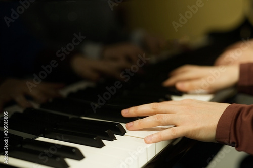 Two young women play on the piano