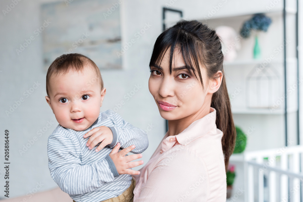 young beautiful mother and little child looking at camera at home young beautiful mother and little child looking at camera at home