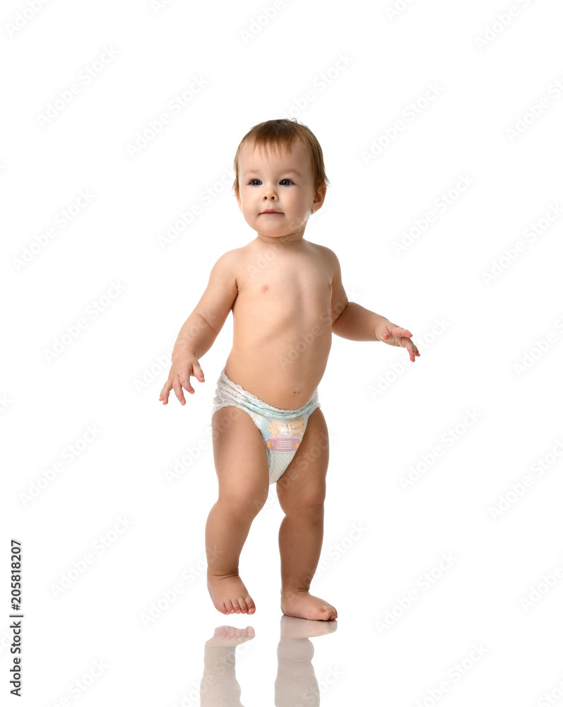 Infant child baby girl kid toddler in diaper make first steps Infant child baby girl kid toddler in diaper make first steps