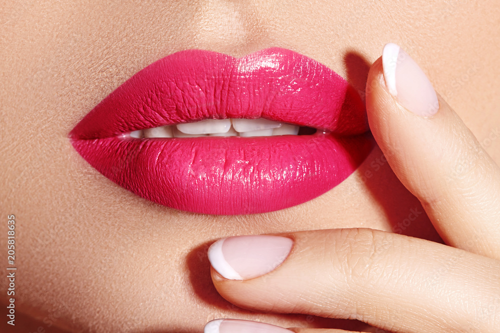 Naklejka premium Close-up macro shot of female mouth. Sexy Glamour red lips Makeup with sensuality gesture. Magenta gloss lipstick