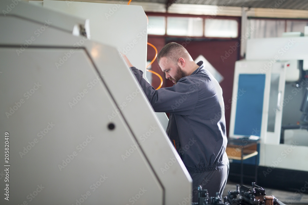 Man working on CNC machine Man working on CNC machine