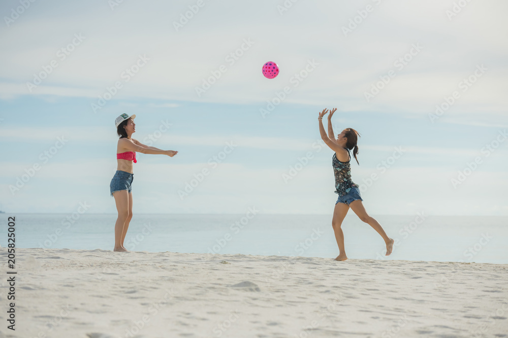friend on a summer beach vacation playing with a beachball and having carefree fun