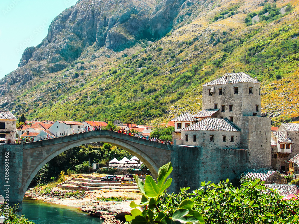 Scenic landscape of Mostar city and old bridge across Neretva river in a lovely summer day. Bosnia and Herzegovina