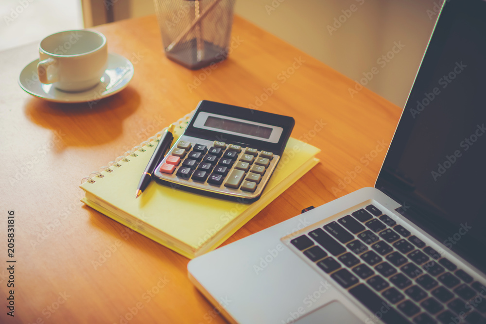 Laptop, coffee cup with financial documents on wooden table Laptop, coffee cup with financial documents on wooden table