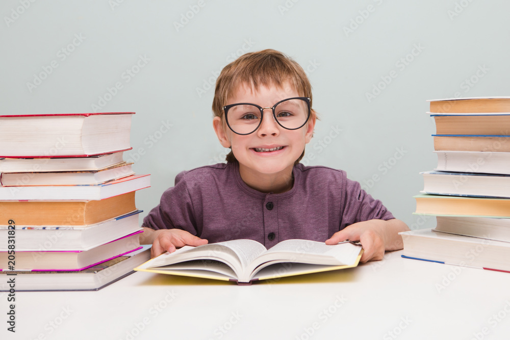 preschooler little boy in glasses reading a book. preschooler little boy in glasses reading a book.