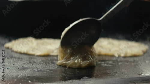 Close up three whitebait fritters cooking on hot stove