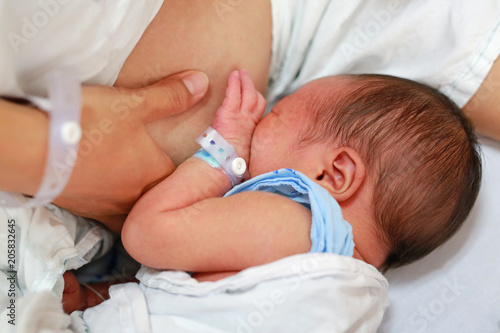 Close up mother breast feeding her newborn child.
