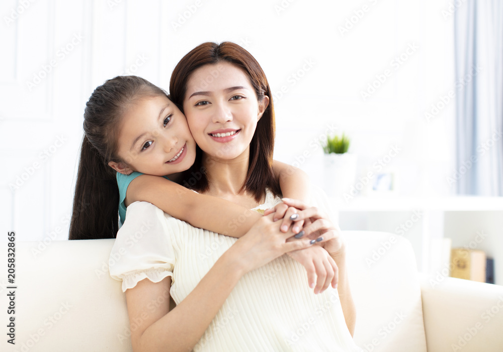 Mother and daughter smiling on couch Mother and daughter smiling on couch