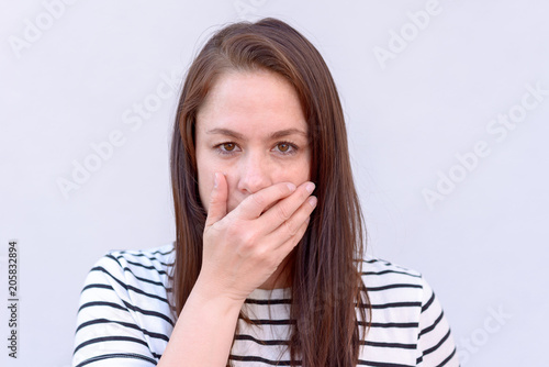 Bild auf Leinwand Young woman with hand over mouth