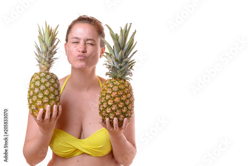 Smiling woman holding two pineapples