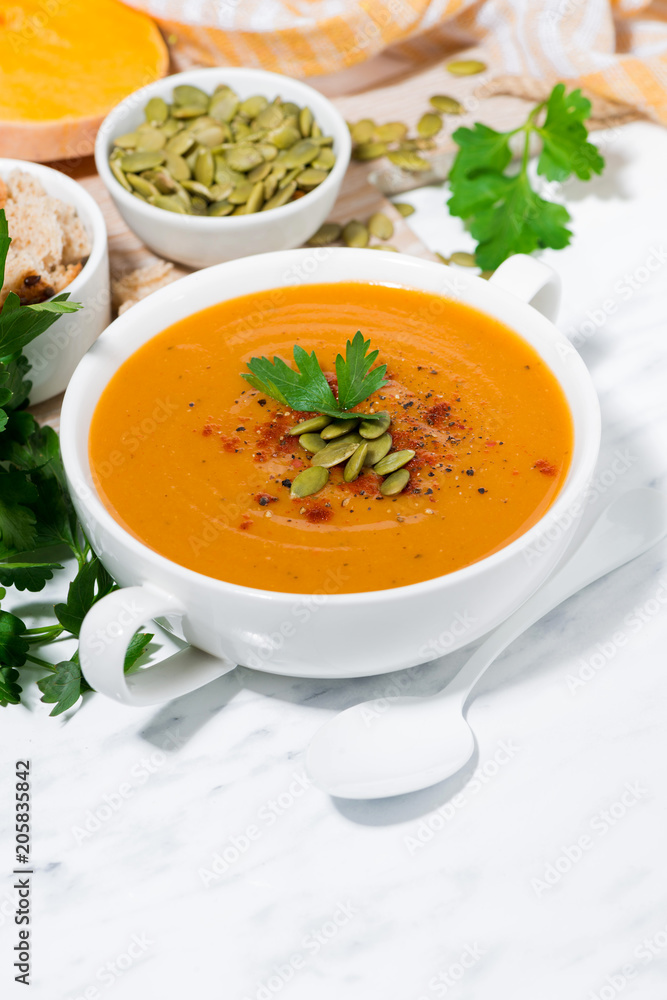 fresh soup of pumpkin and lentils on white background, vertical