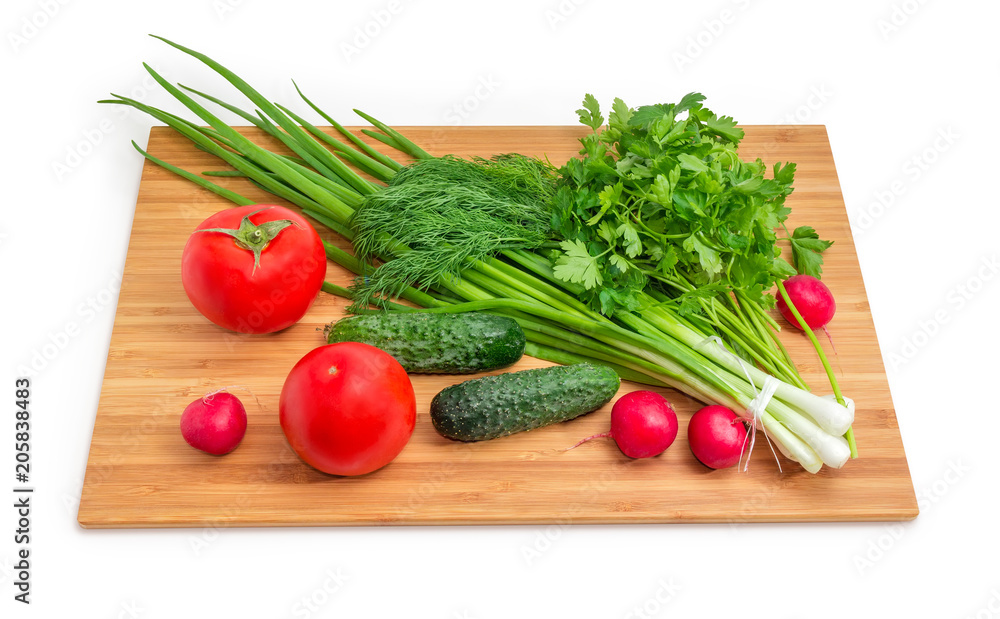Fresh vegetables and greens on the bamboo cutting board Fresh vegetables and greens on the bamboo cutting board