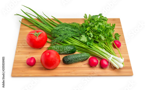 Fresh vegetables and greens on the bamboo cutting board
