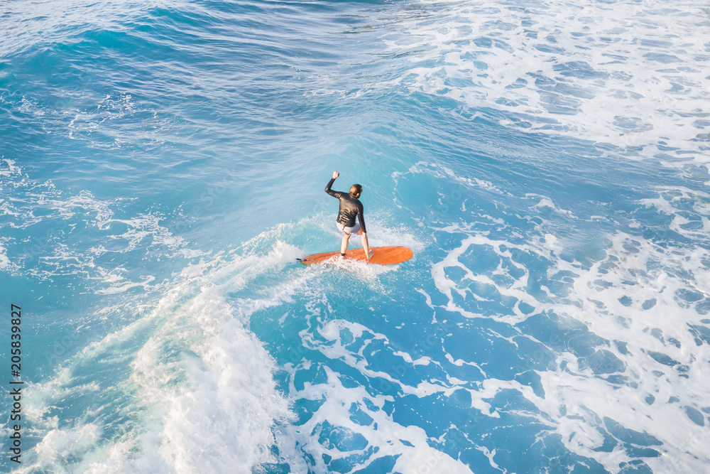 Surfer on a surfboard in the water, top view