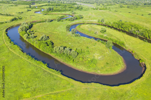 Top view of a winding river in a green valley