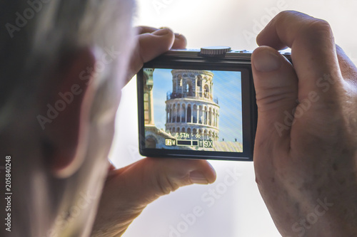 A man is making a photo of the Tower of Pisa