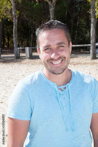 Fototapeta Naklejka Na Ścianę i Meble -  smiling handsome man in sand beach summer vacation
