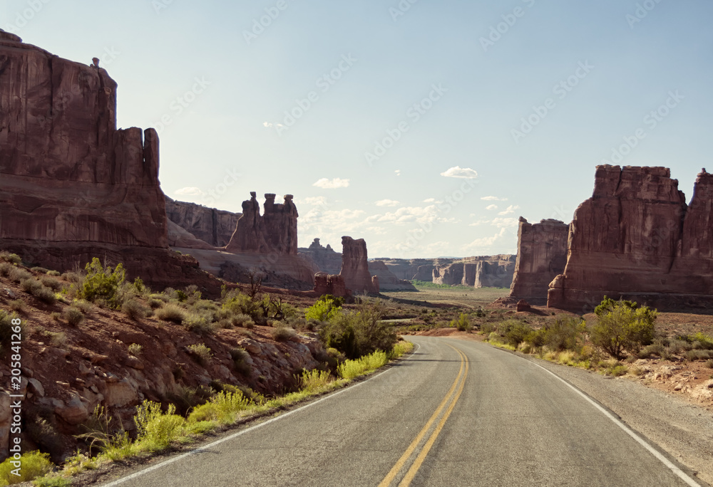 Vintage toned picturesque American desert highway in daylight with clear sky for copyspace. Concept for travel and freedom