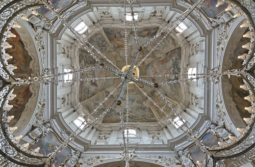 Low angle view of the beautiful frescod dome of the Church of Saint Nicholas with a crystal cross in the center. The Church of Saint Nicholas is a Late-Gothic and Baroque church in Old Town of Prague