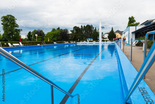 Blick über ein Schwimmbecken eines Freibades mit ruhigem Wasser vor der Öffnungszeit © jeho.photography