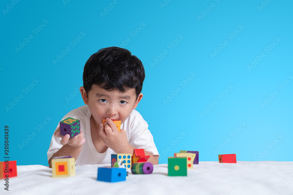 3 years old little cute Asian boy play toy or square block puzzle at home on the bed, kid lying learn by playing block shape or pieces, education and healthy concept idea. 3 years old little cute Asian boy play toy or square block puzzle at home on the bed, kid lying learn by playing block shape or pieces, education and healthy concept idea.