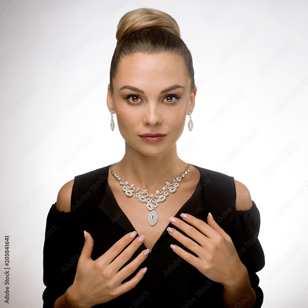 Brunette with well-groomed hair. A beautiful model in a black dress with  jewelry. Perfect makeup and jewelry. Stock Photo | Adobe Stock