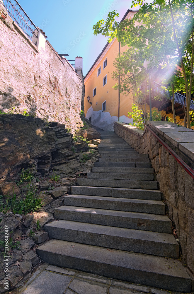Ancient narrow stairs in Cesky Krumlov at sunny day. The historical center of the city in 1992 is listed as a UNESCO World Heritage Site. Czech Republic