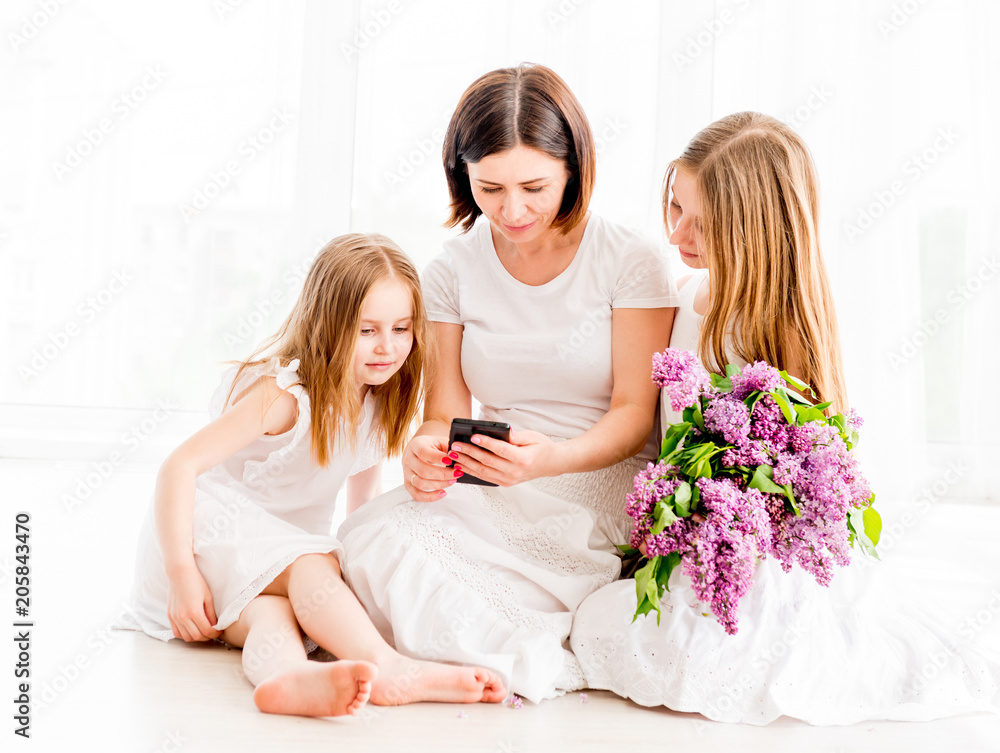 Mother with daughters looking at smartphone Mother with daughters looking at smartphone