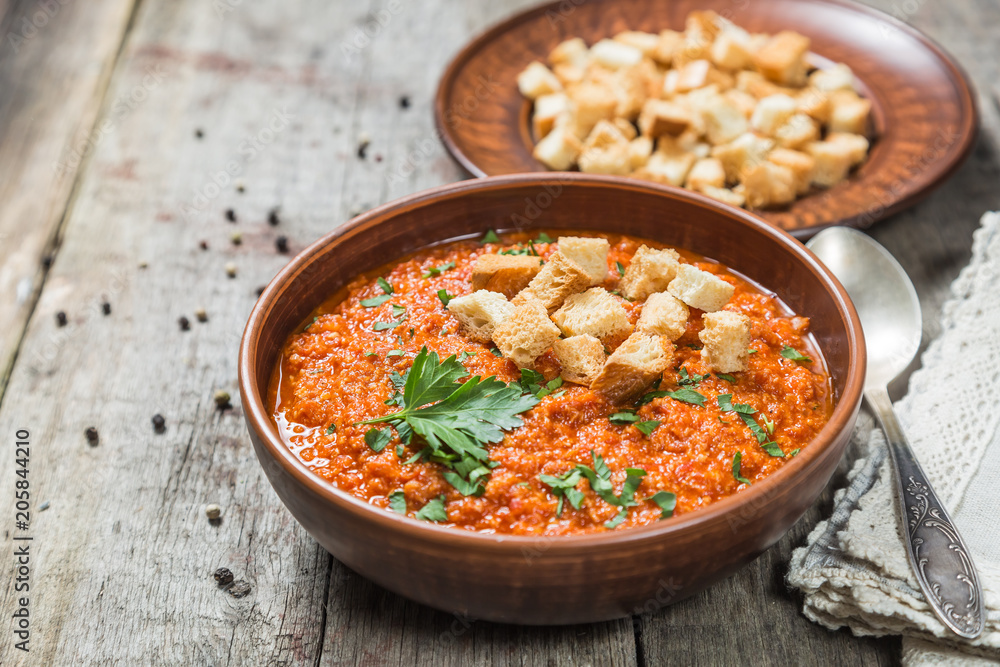 Tomato soup on a table of old wooden boards. Copy-space.
Tomato soup on a table of old wooden boards. Copy-space.
