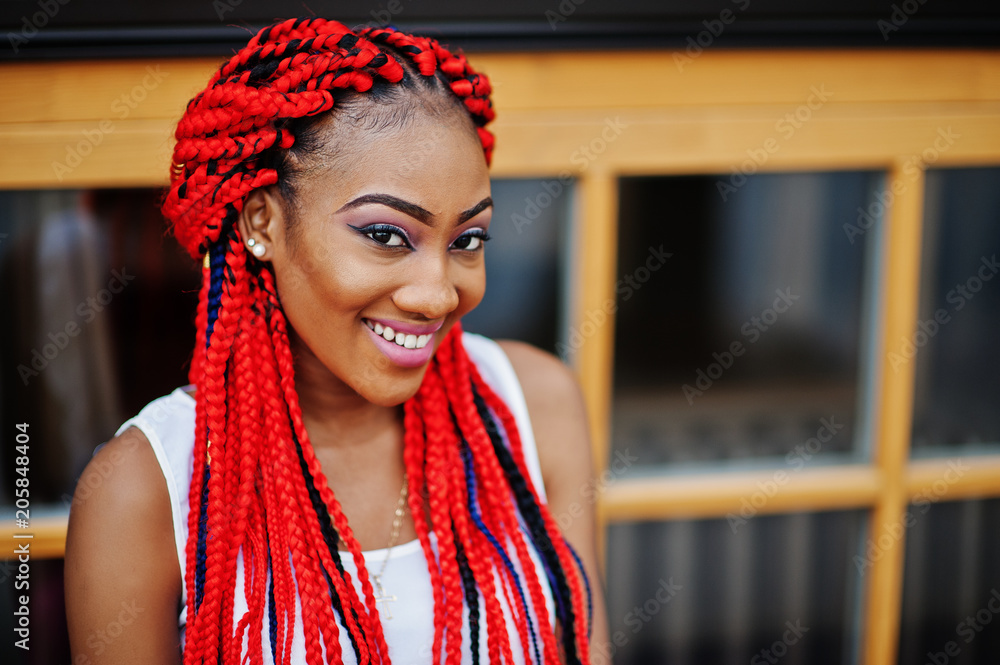 Fashionable african american girl at pink pants and red dreads posed outdoor. Fashionable african american girl at pink pants and red dreads posed outdoor.